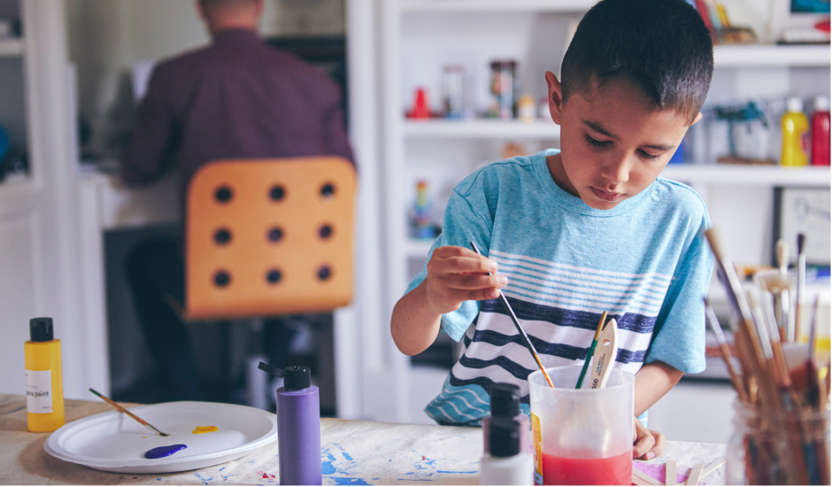 Alumno de primaria pintando en casa