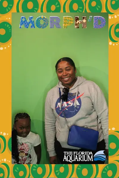 Un adulto y un niño sonrientes sobre un fondo verde.