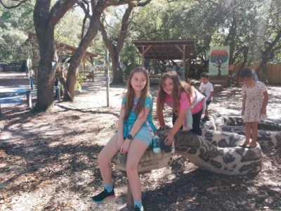 Los niños juegan en una gran escultura con forma de serpiente.