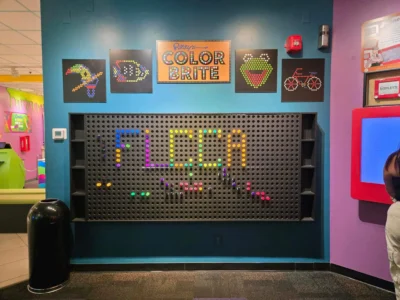 Colorido expositor de pared con la palabra "FLCCA" en tonos vivos.