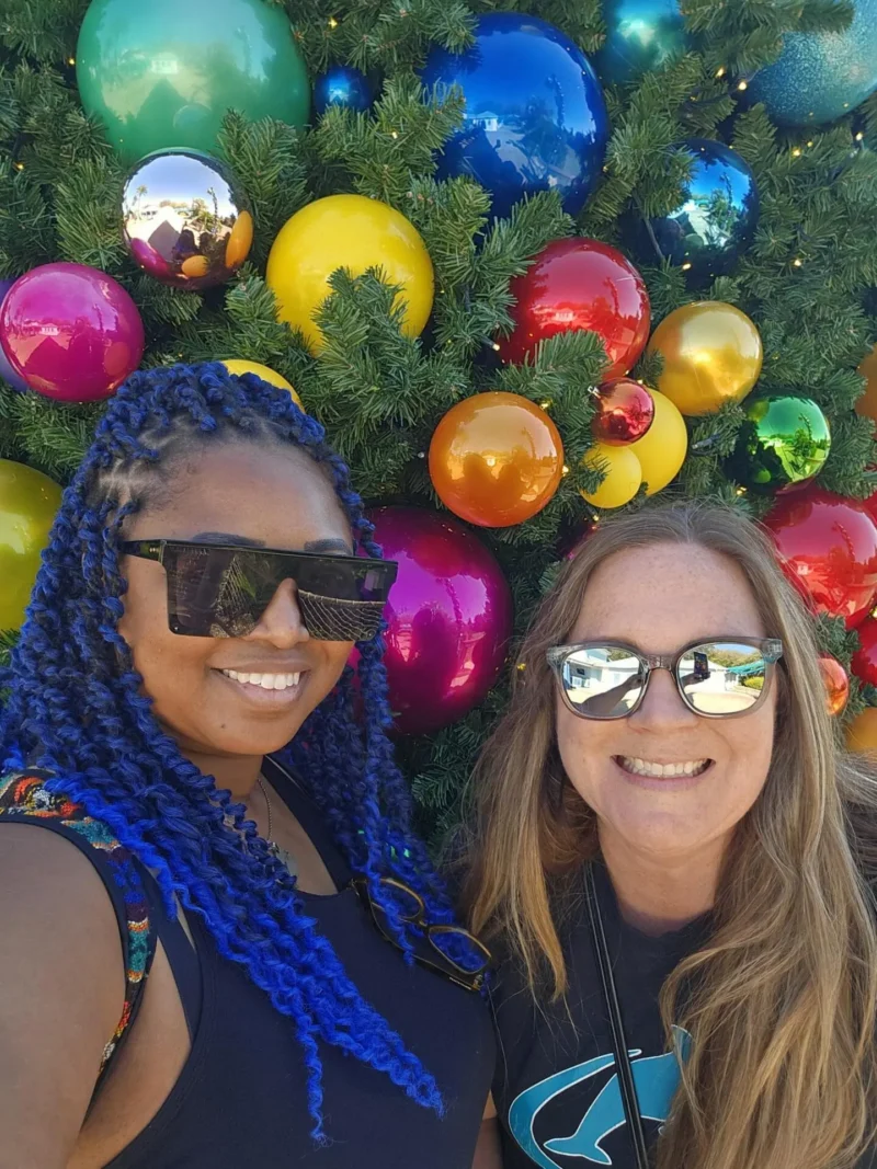 Chica con pelo azul sonriendo junto a chica rubia